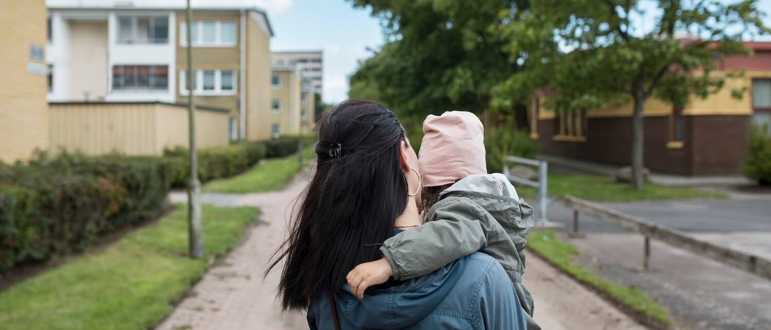 Mother carrying her little daughter outside