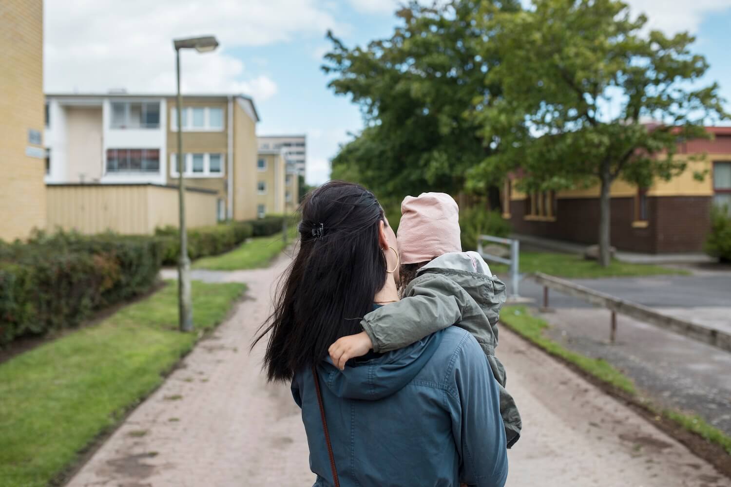 Mother carrying her little daughter outside